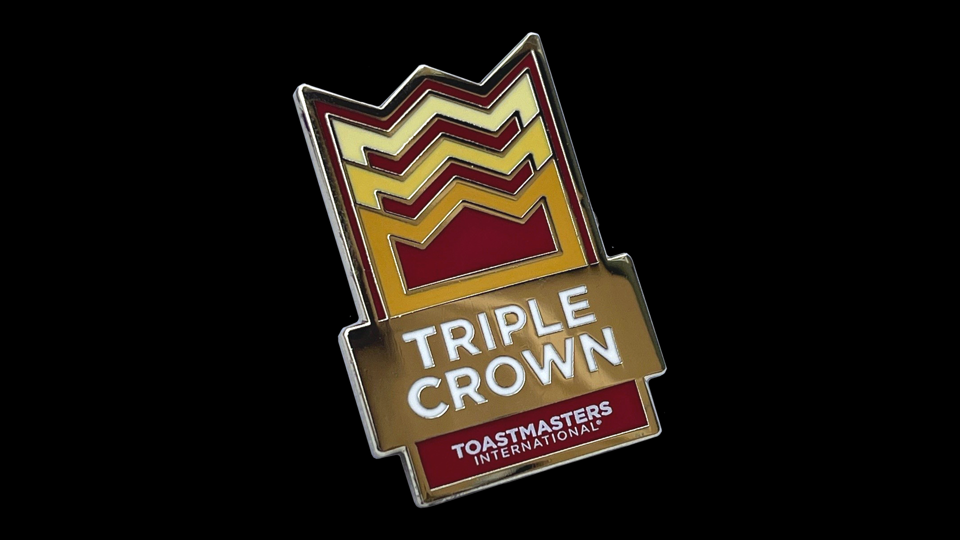 Image of a triple crown pin on a black background