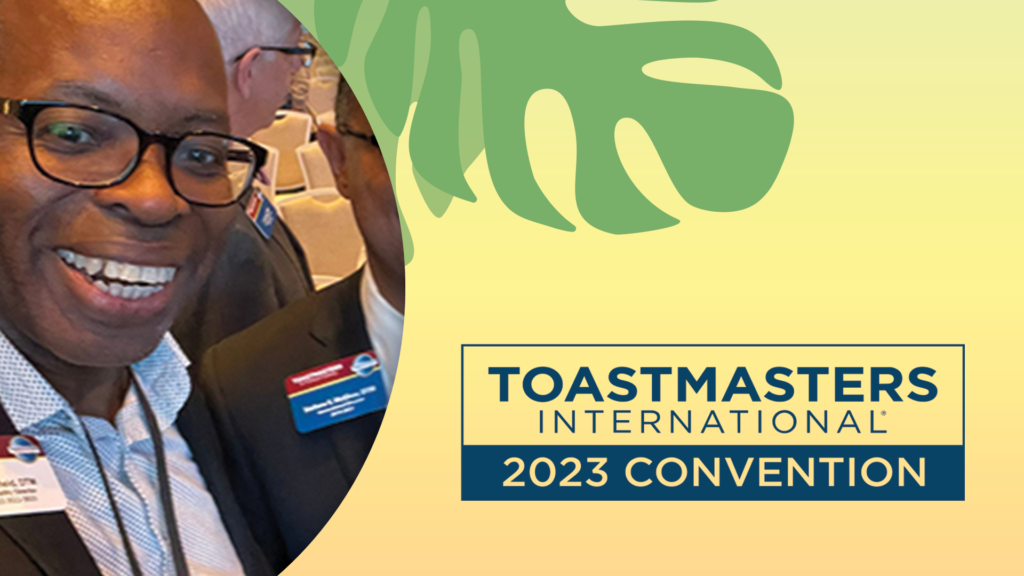 Leslie Smiling with the Toastmasters International 2023 Convention Logo